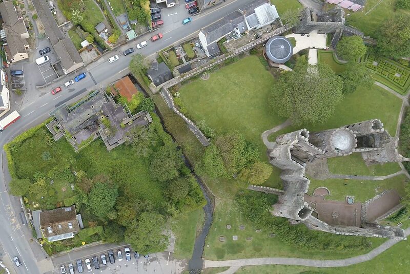 Island House before the restoration began: the house and its overgrown ground seen from the air, roofs failing and the plot untended.